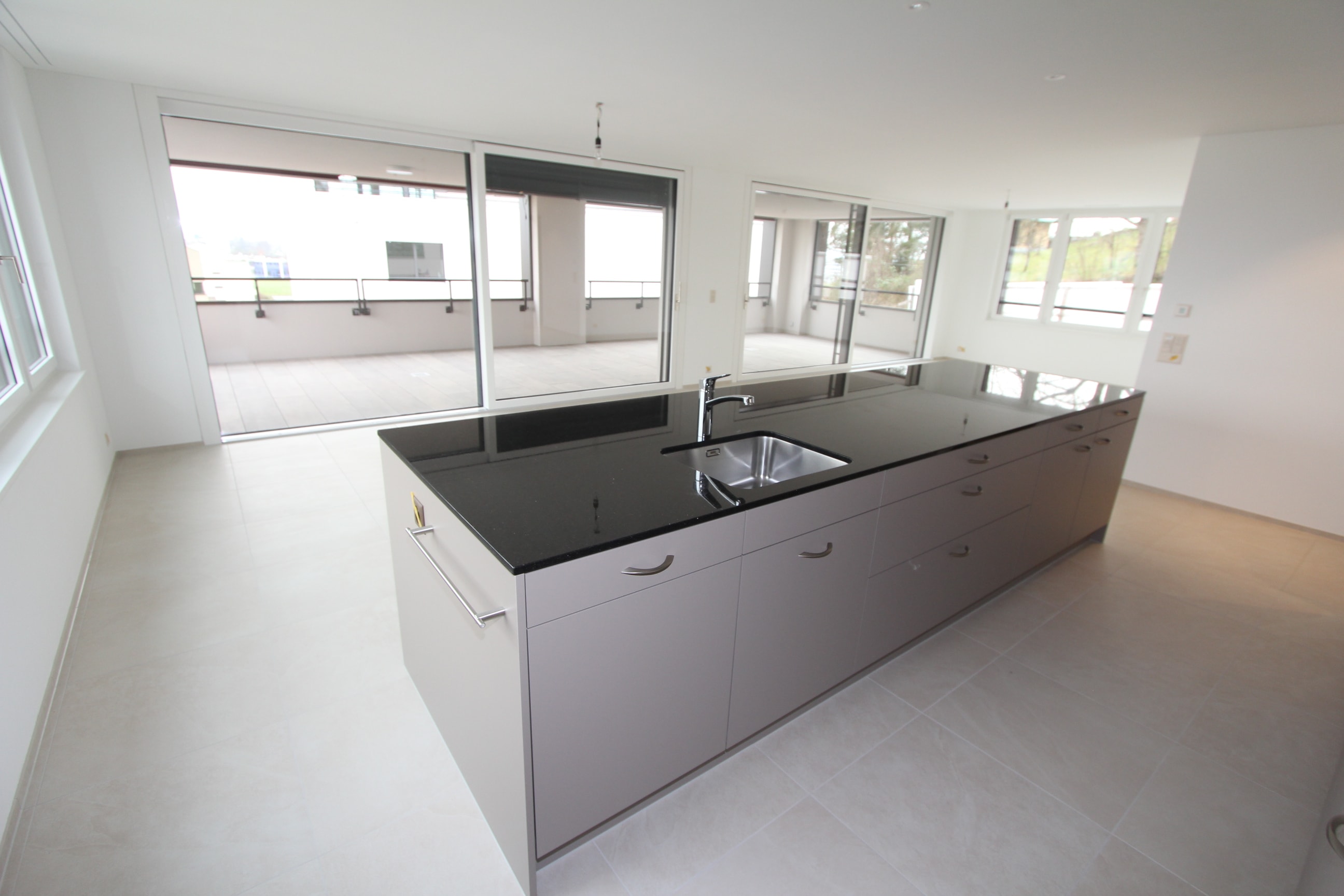 Offene Küche mit Wohn- und Essbereich und Blick auf den Balkon ?